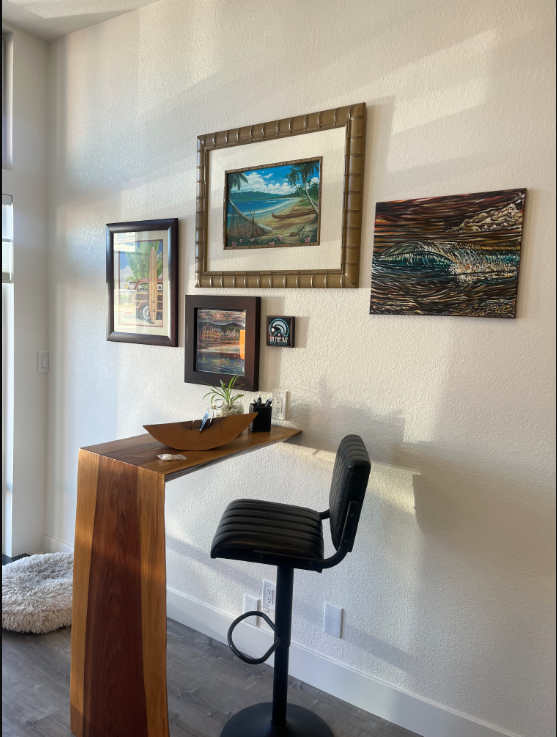Epique Texas office — styled corner with coastal art and live-edge desk